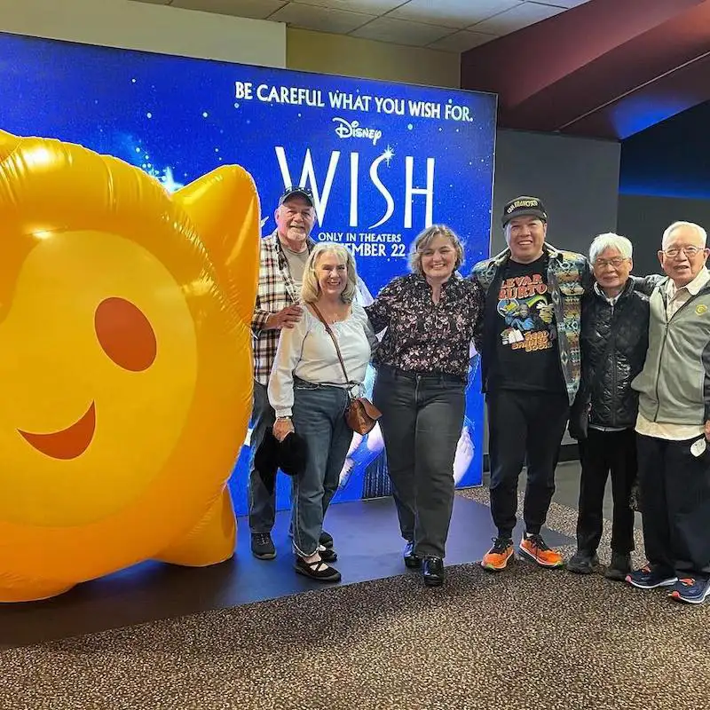 Belmont Alumnae stand in front of 'WISH' movie display
