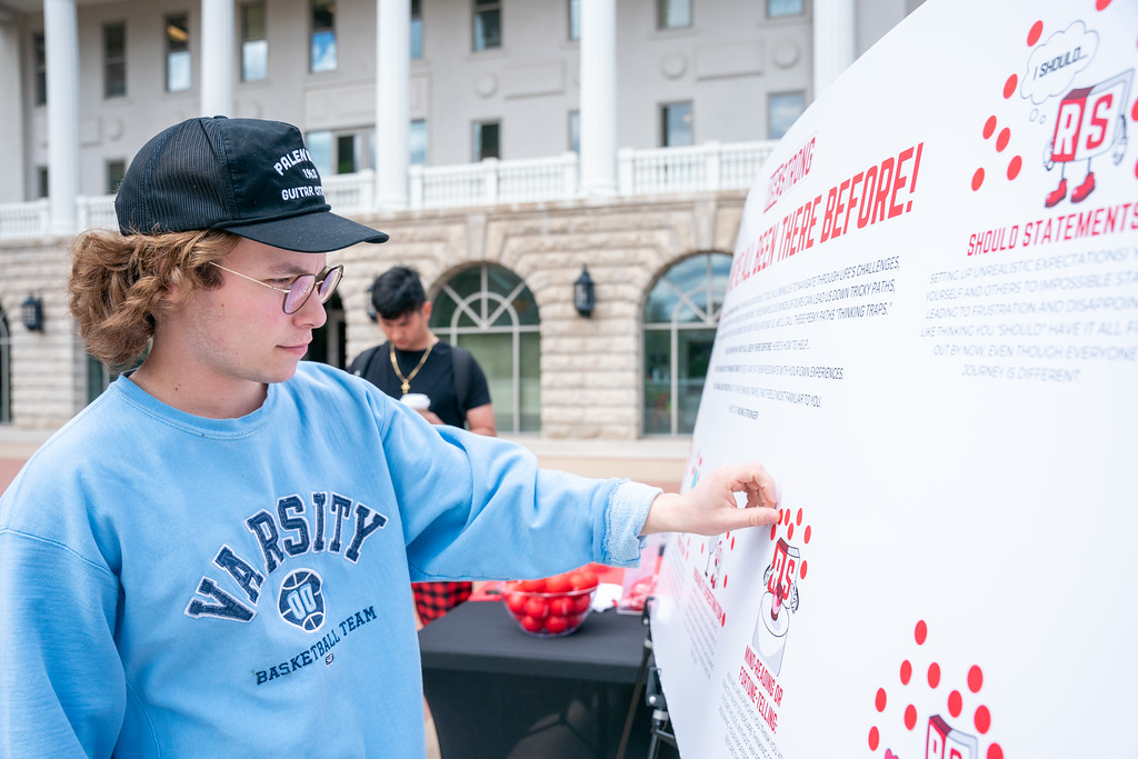 student looks at a pop-up event poster