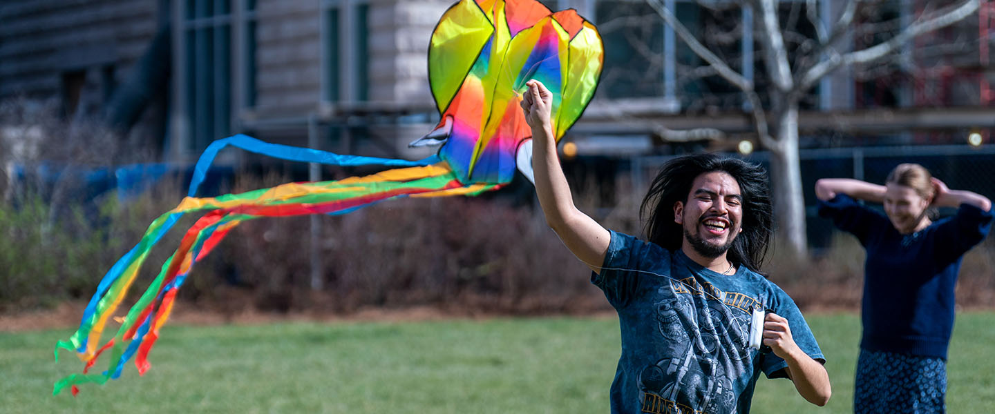 A member of kite club launches a multicolor kite on the lawn