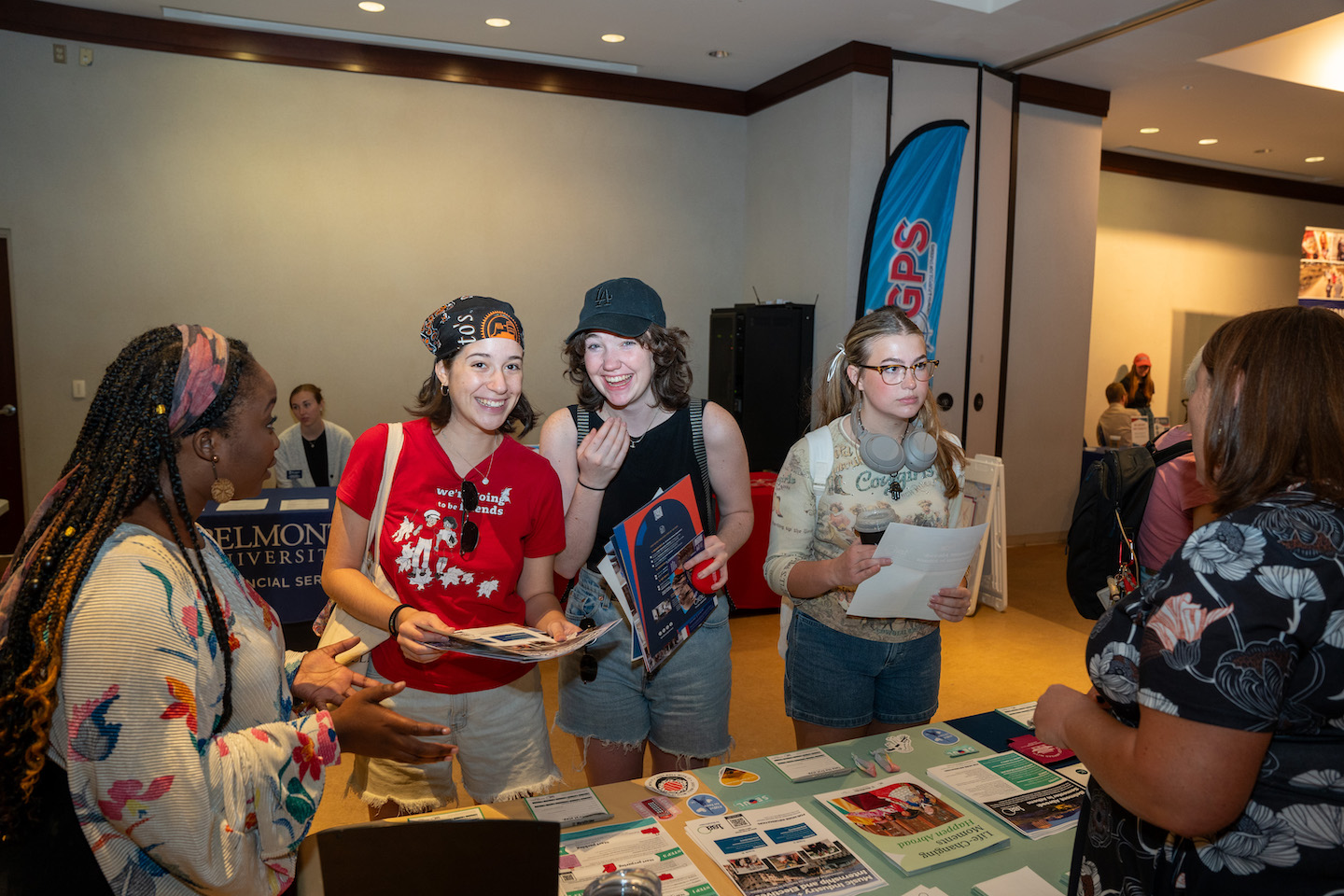 students smile while checking out a booth at the global fair