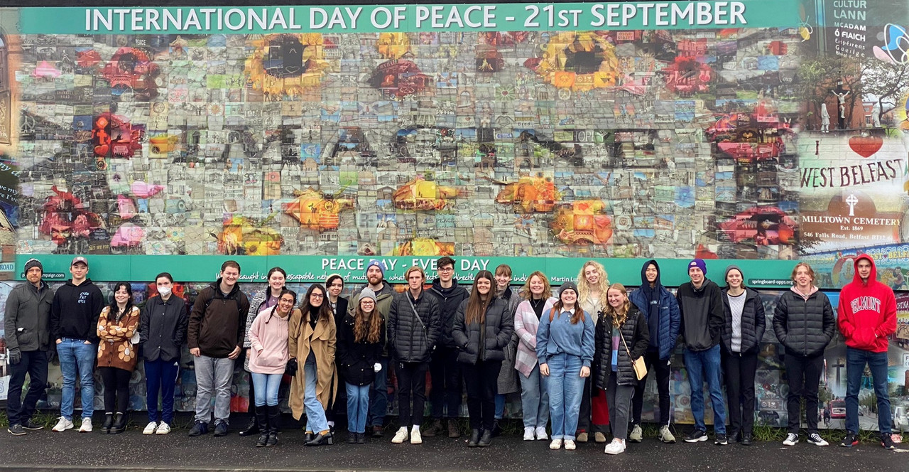 Students line up in front of the Peace Wall in Belfast