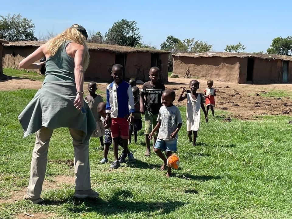 Rachel Hacker playing soccer with children in Kenyan village