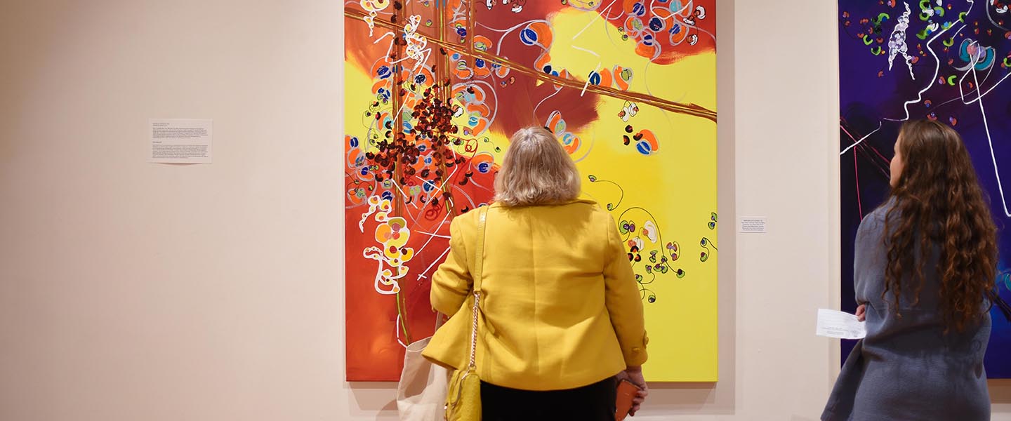 Woman in Watkins Art Gallery viewing a piece of artwork