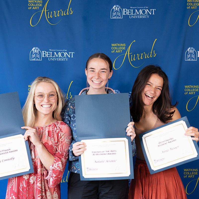 Students smiling showing awards they have won