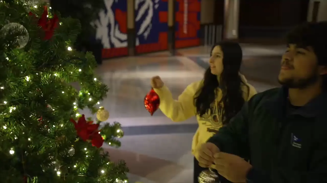 Students hanging ornaments on a Christmas tree