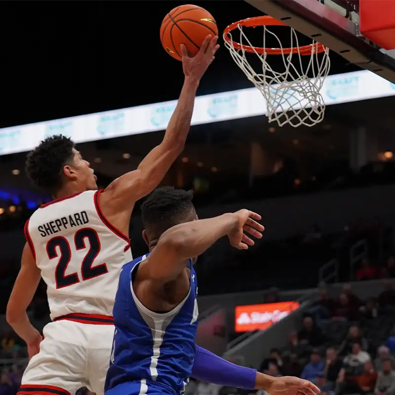A basketball player wearing jersey number 22, Sheppard, performs a slam dunk while another player defends in the foreground.