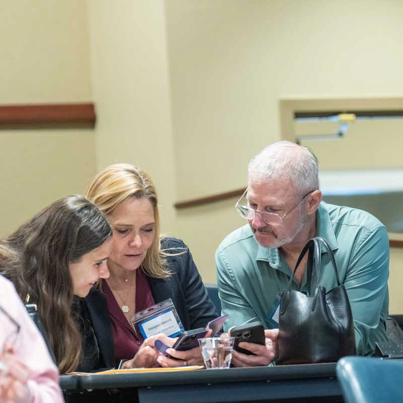 Three people gathered at symposium