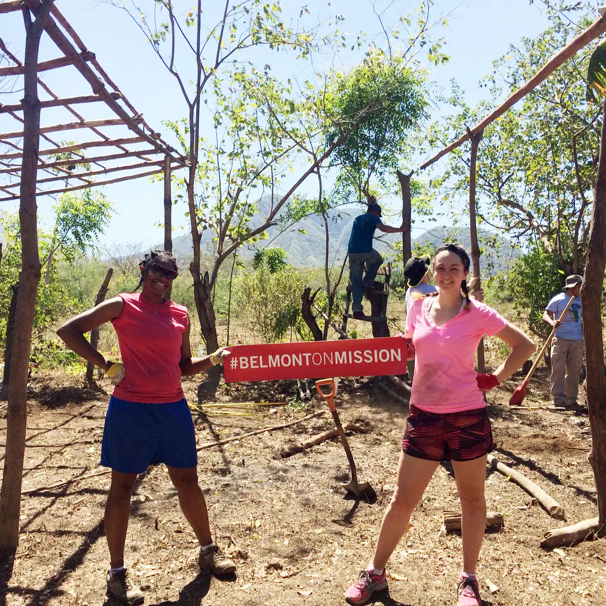 Belmont University students participate in an outdoor service project during Belmont on Mission, holding a “#BelmontOnMission” banner.