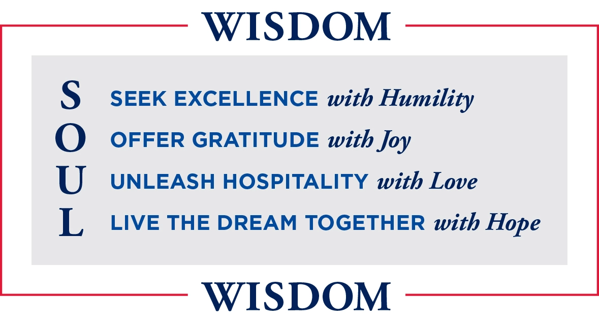 An image with the word "WISDOM" at the top and bottom in bold gold text. In between, the acronym "SOUL" is displayed vertically with each letter standing for a value:  S - Seek Excellence O - Offer Gratitude U - Unleash Hospitality L - Live the Dream Together