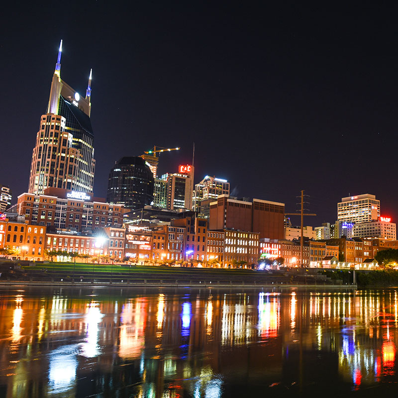 Nashville skyline at night with the lights reflecting off the river