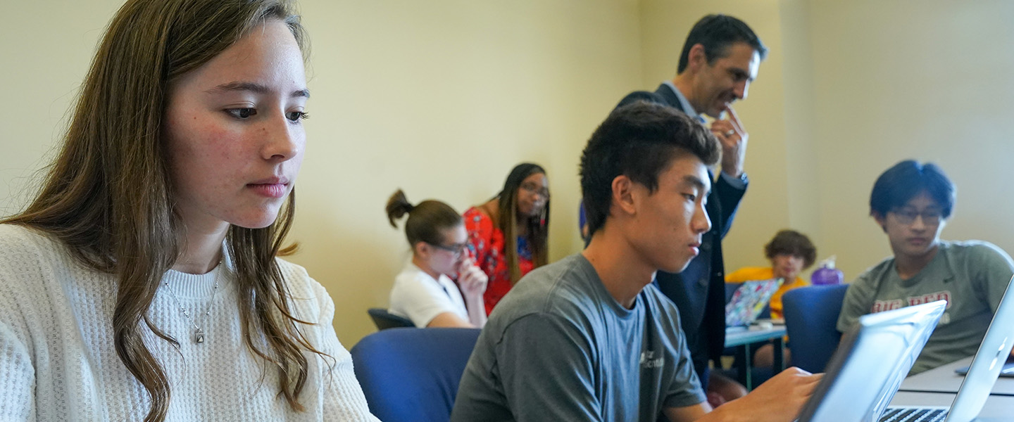 Two students look intently at their laptops.