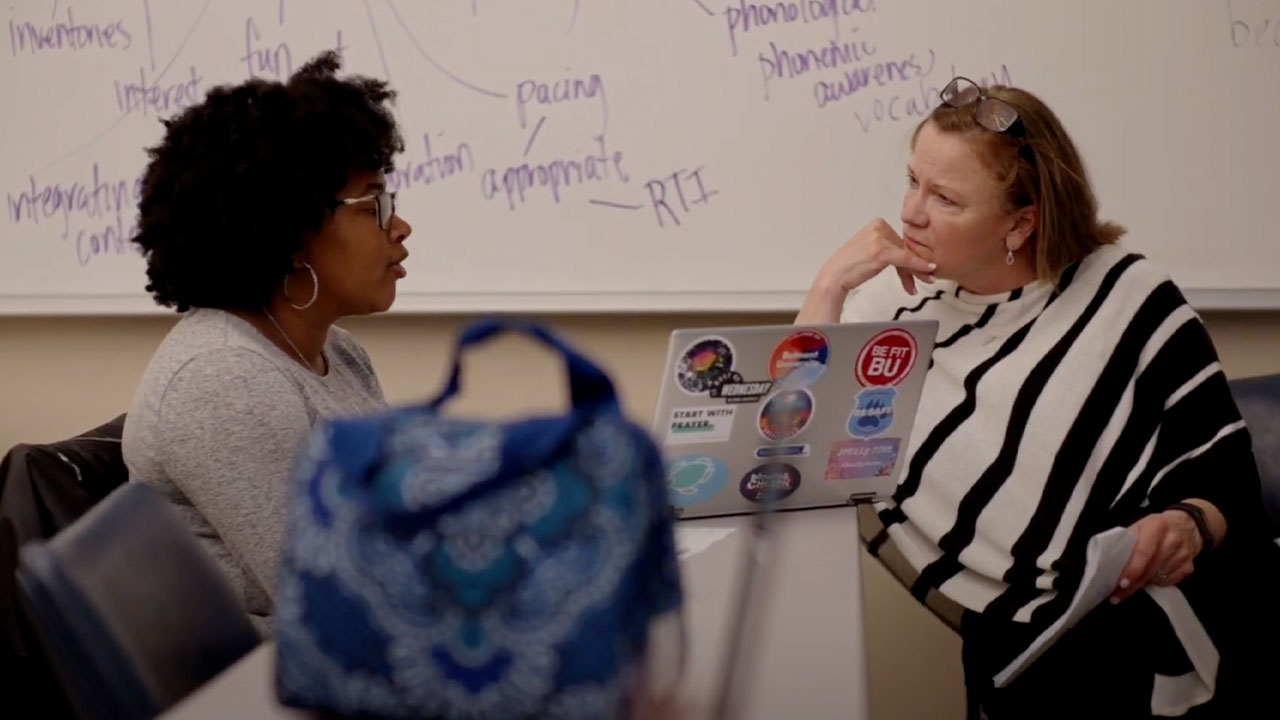 A student and a professor talk during class