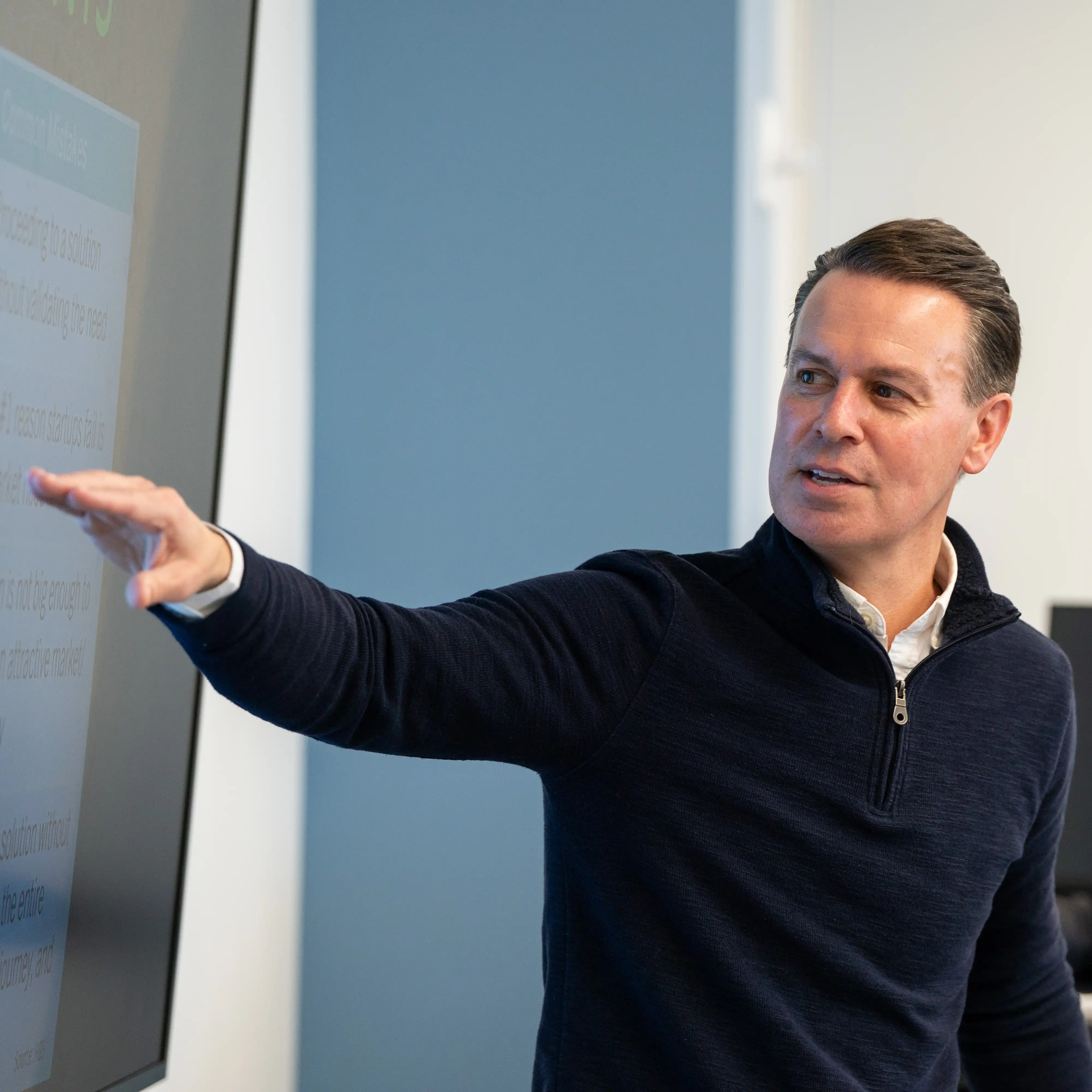 faculty member leads an interactive classroom discussion, using digital technology to guide students through real-world financial concepts and investment strategies.