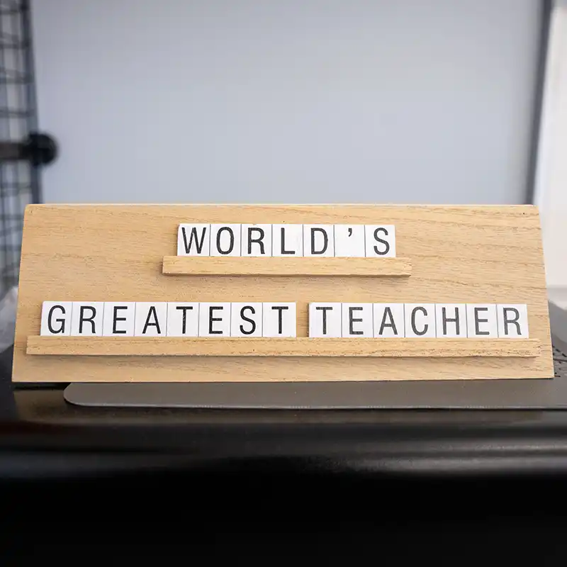 A decorative classroom sign reading "World's Greatest Teacher" reflects the supportive, student-centered environment of Belmont's teacher education programs.