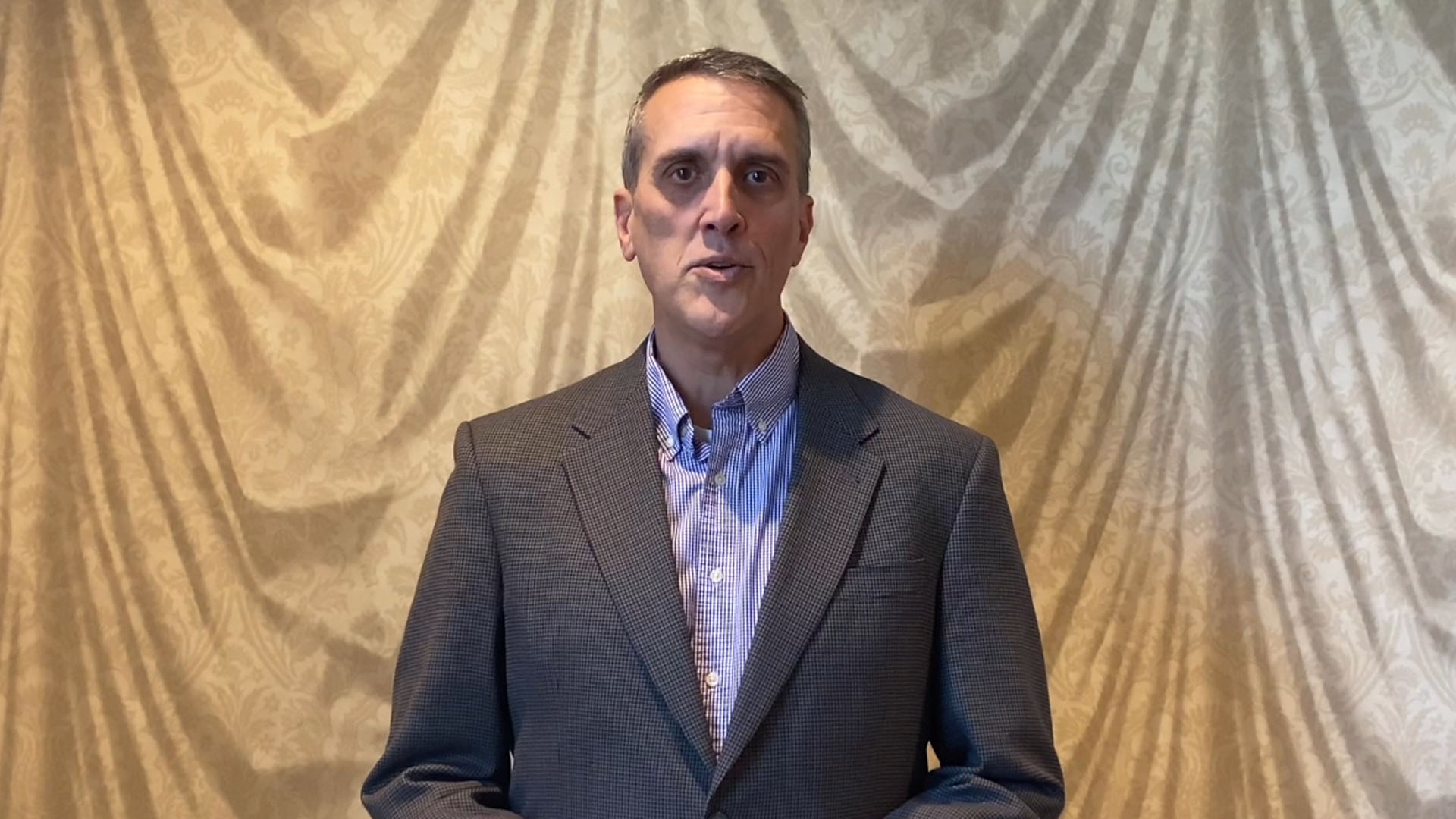 Dr. Barry Kraus standing in front of a curtain