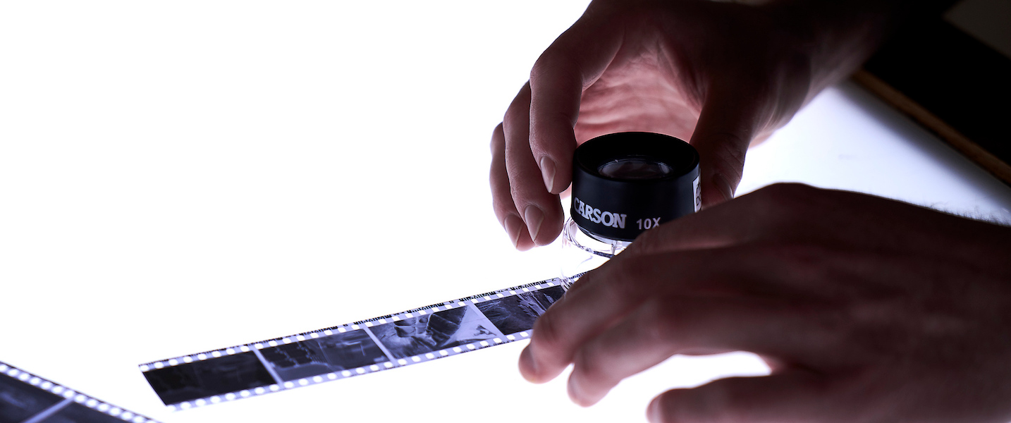 Student examines negatives over a lightboard 