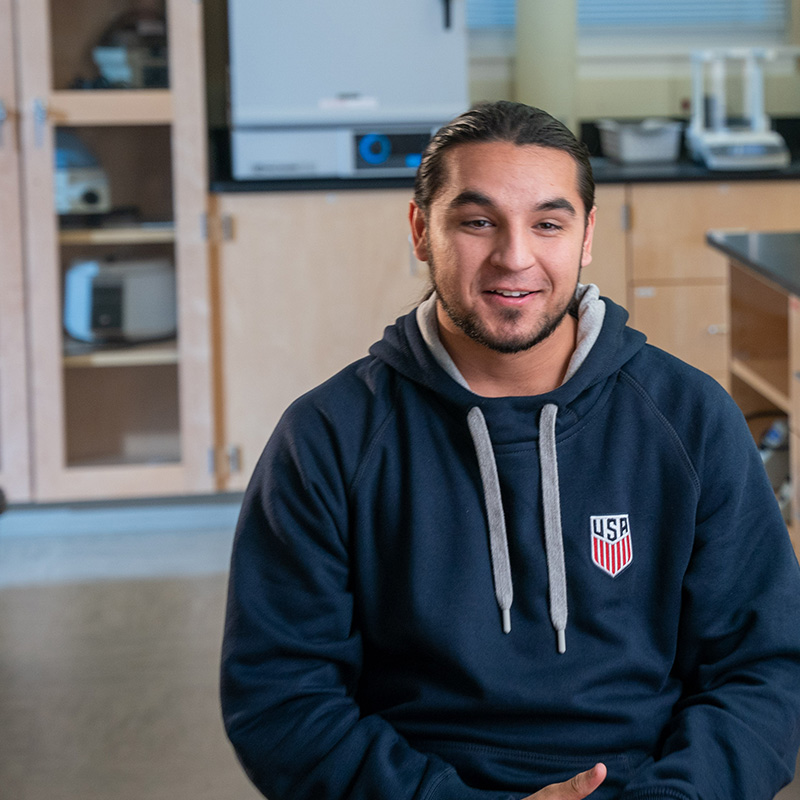 student Alec Khatter sits in Belmont lab