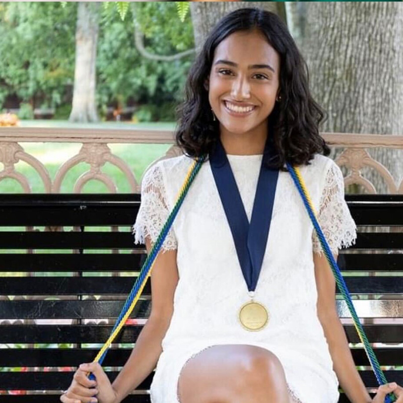 alum Aleya Prasad sitting at a Belmont gazebo