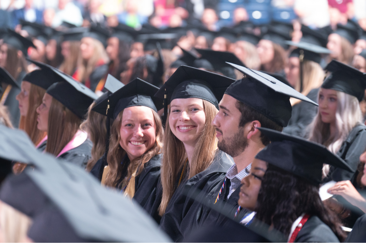 Photo of graduates sitting in Curb Event Center on commencement day
