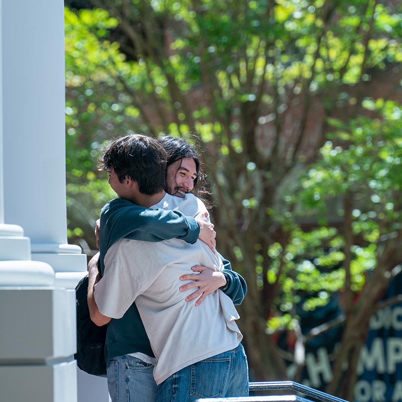 2 students hugging outside of Beaman student life center