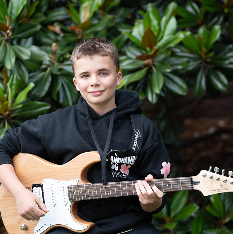 A young boy with an electric guitar