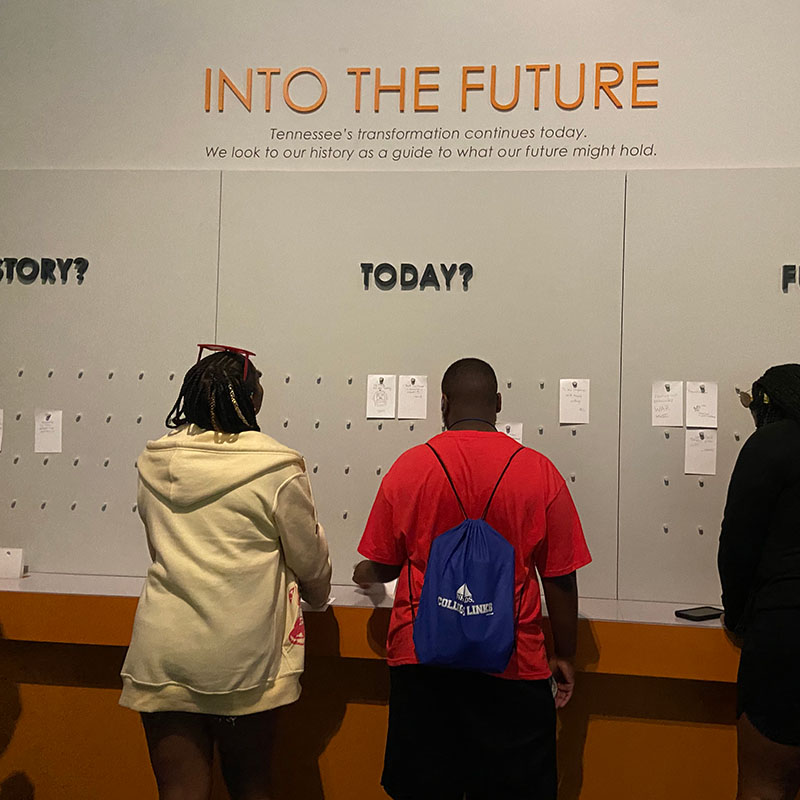 Students standing in front of an exhibit called Into the Future