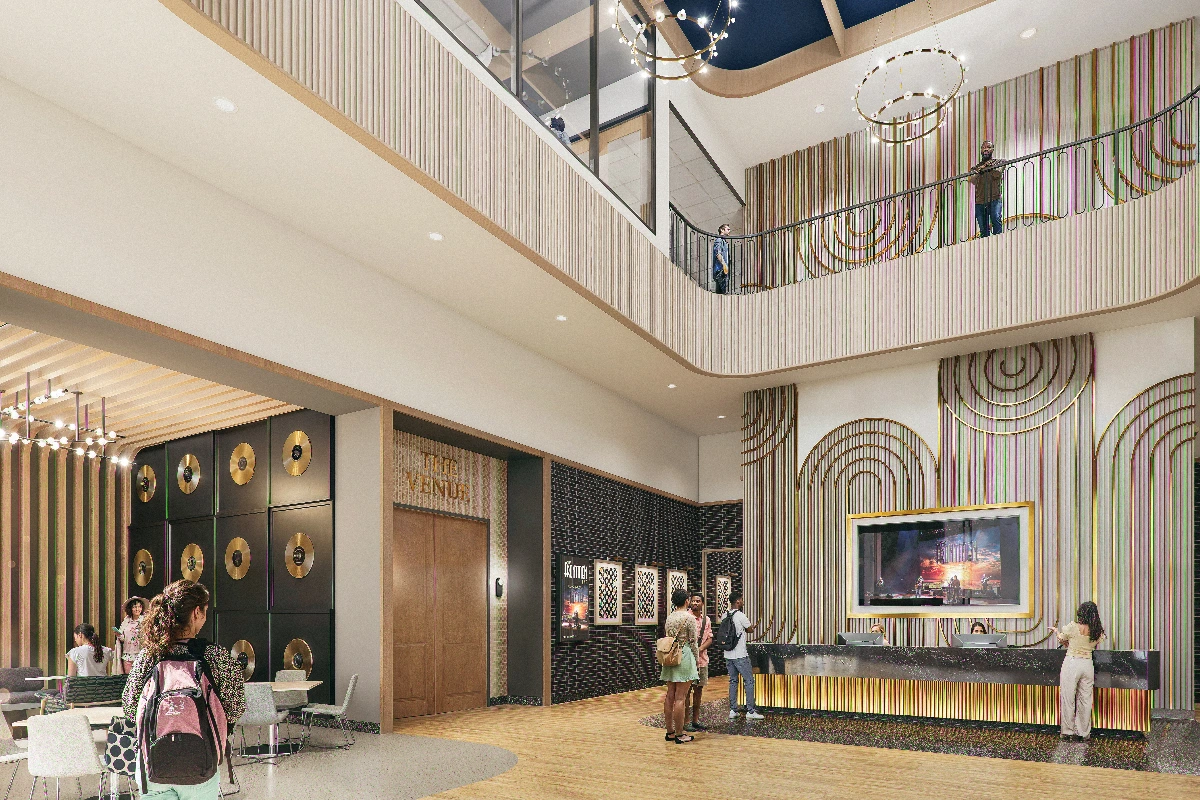 Modern, vibrant Mike Curb building lobby with a multi-level design, a sleek reception desk, large screen, gold accents, and people.