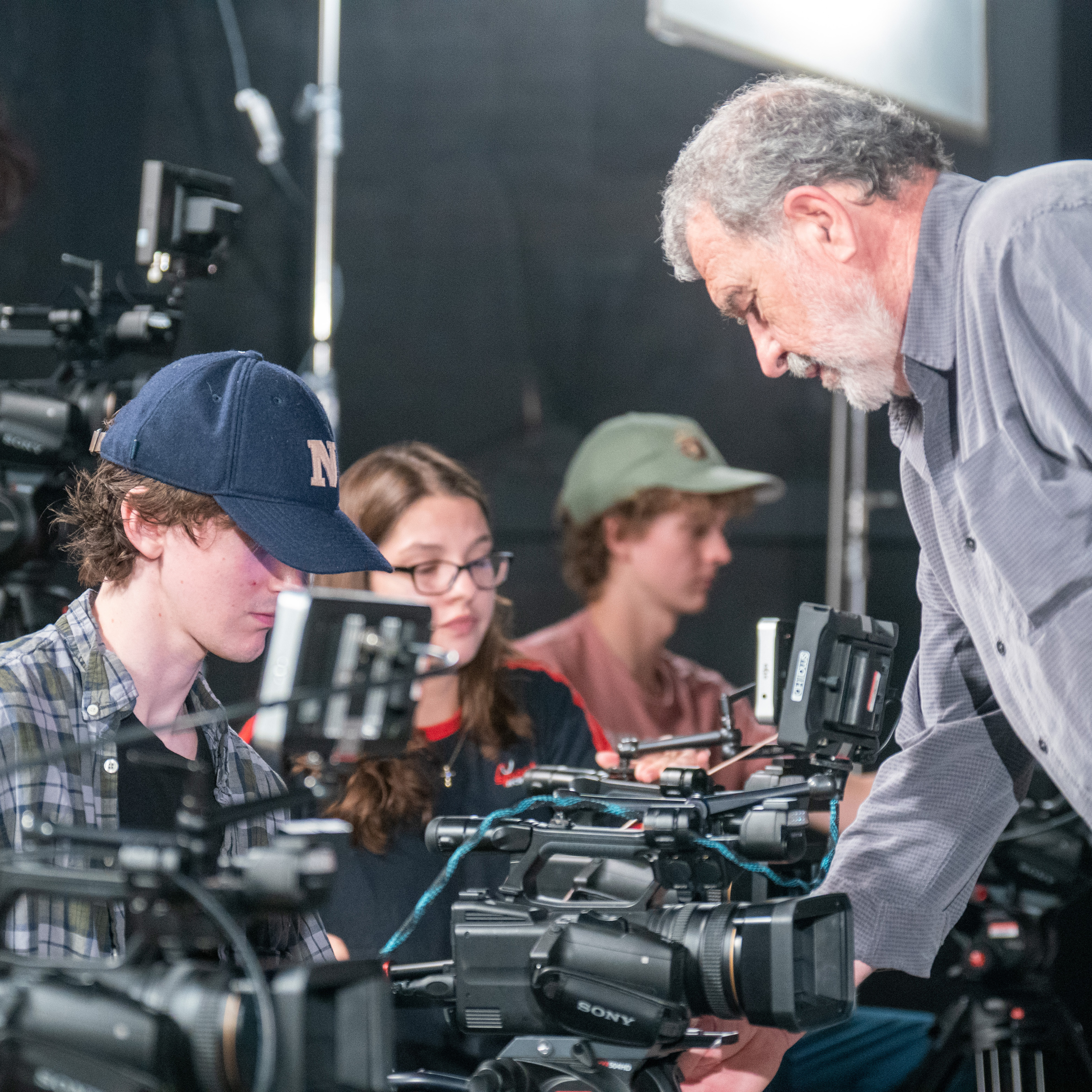 Faculty member helping student with camera in film class