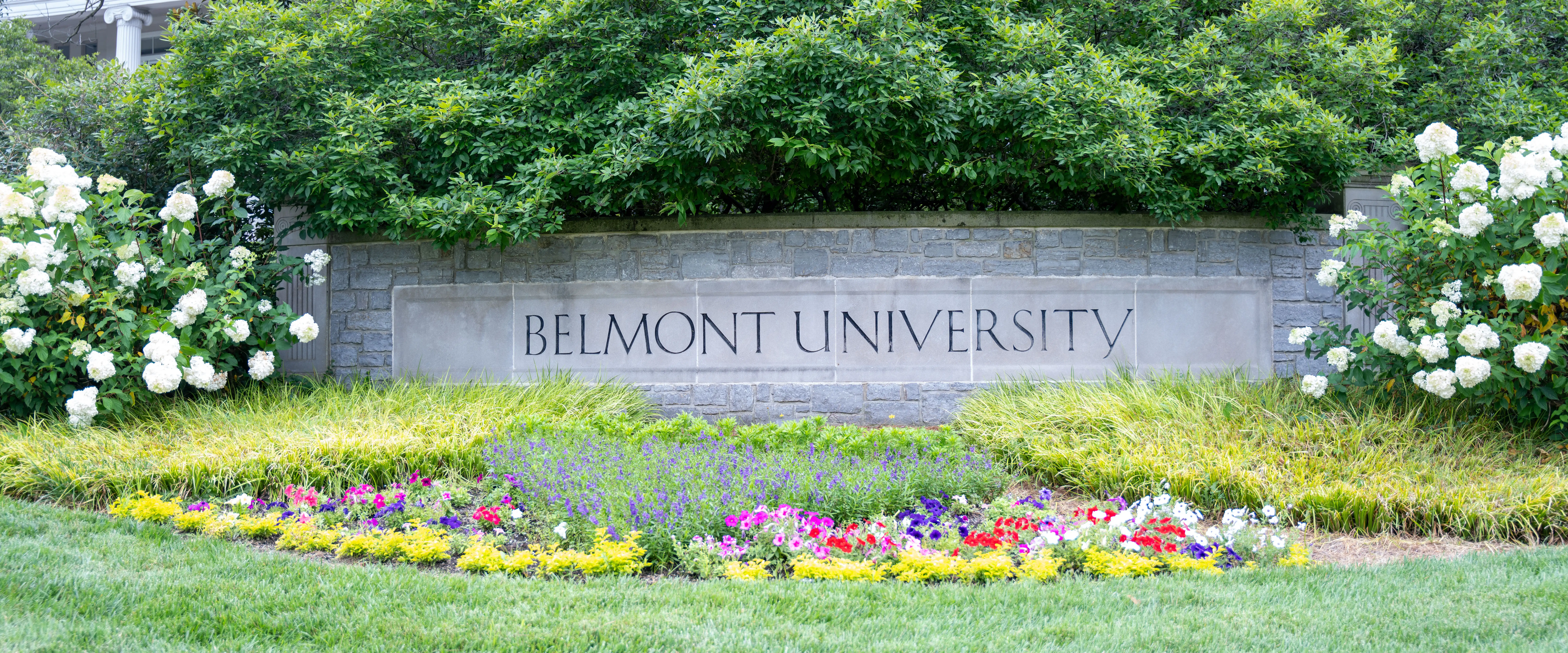 Belmont University stone sign surrounded by flowers