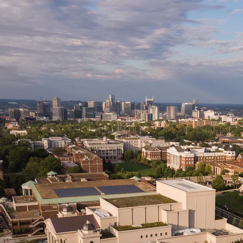 An aerial shot of campus at golden hour with the city of Nashville and a partly cloudy sky in the distance