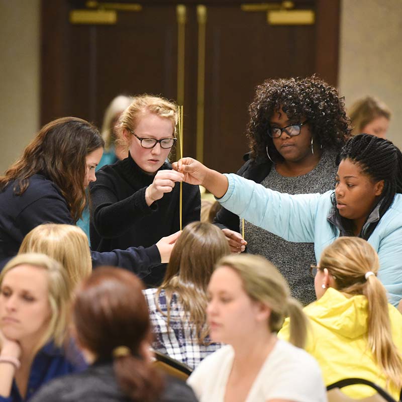 Students working together to build a tower during an Interprofessional engagement event 
