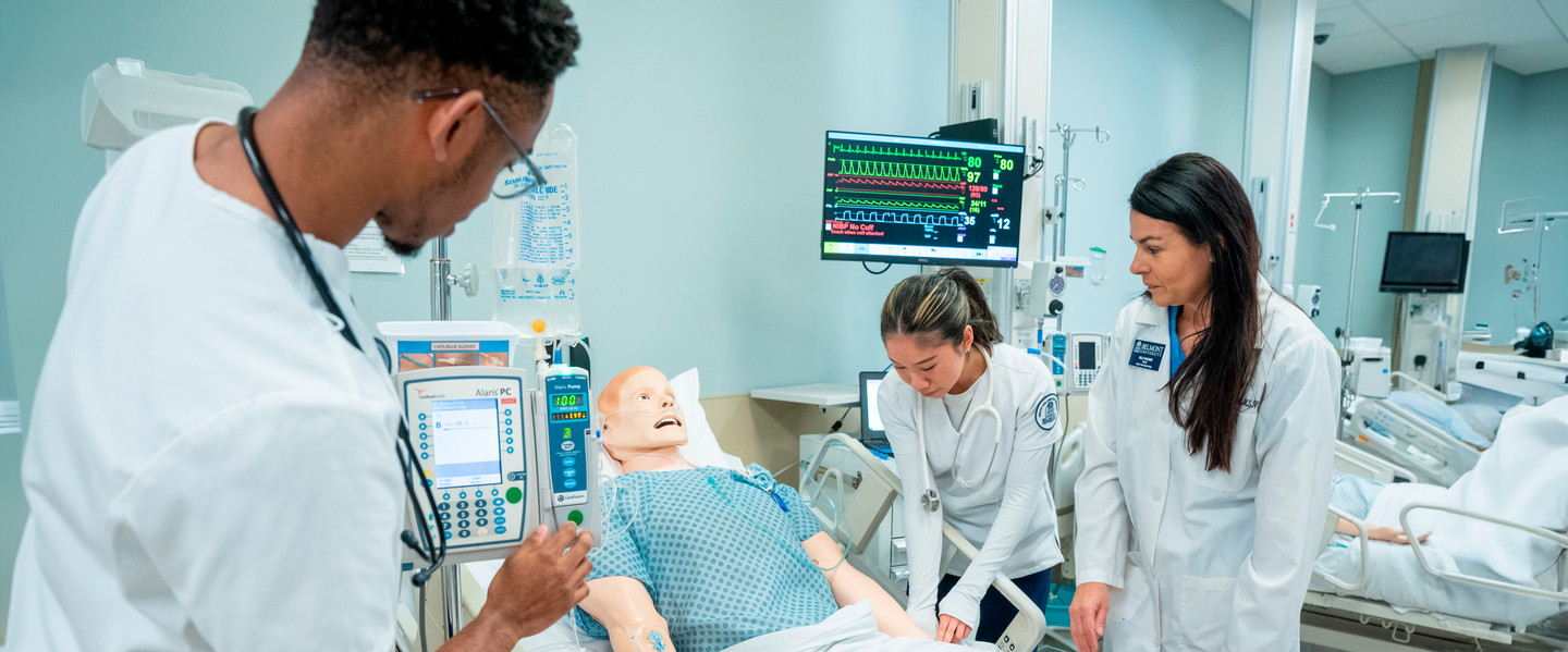  Nursing Students working on Sim Lab dummy with professor