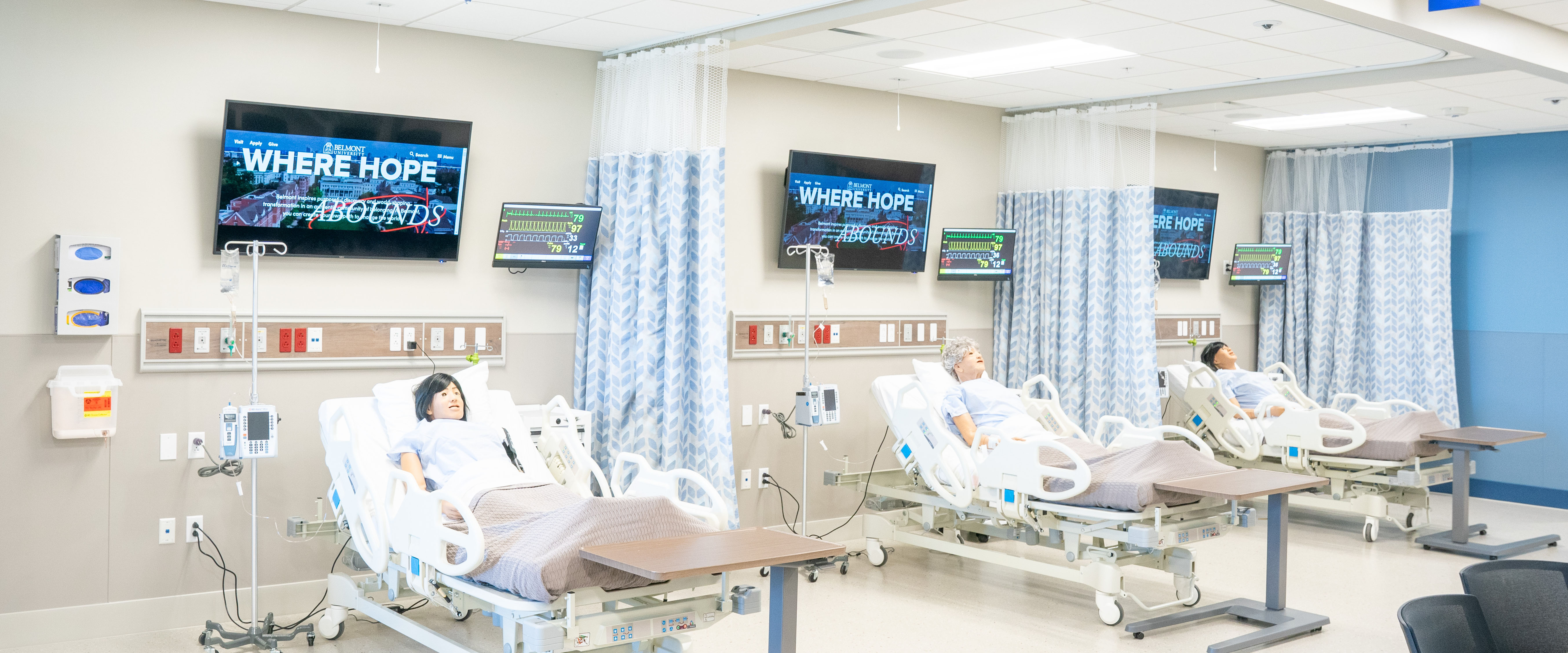 Simulation lab filled with hospital beds and medical dummies for students to practice on