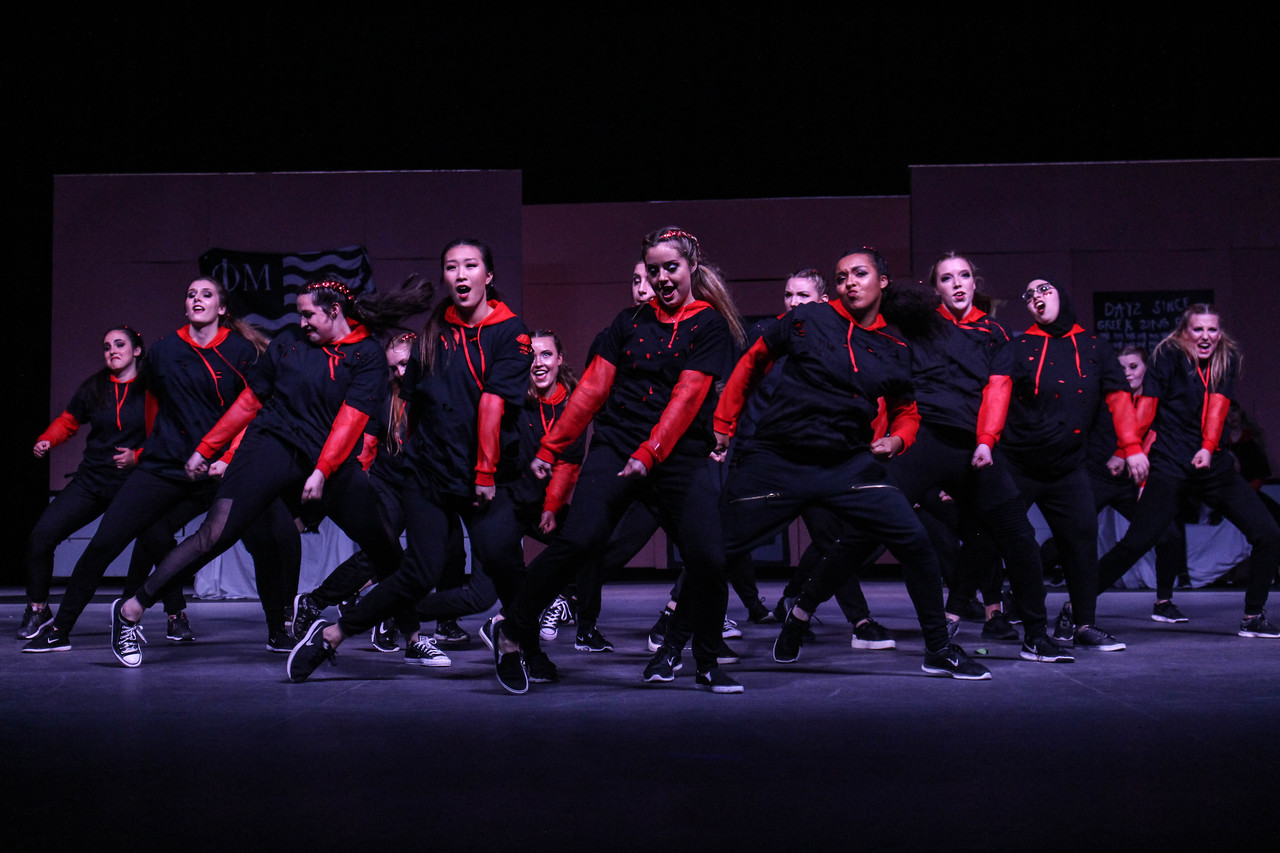 A sorority performs a song and dance routine on stage