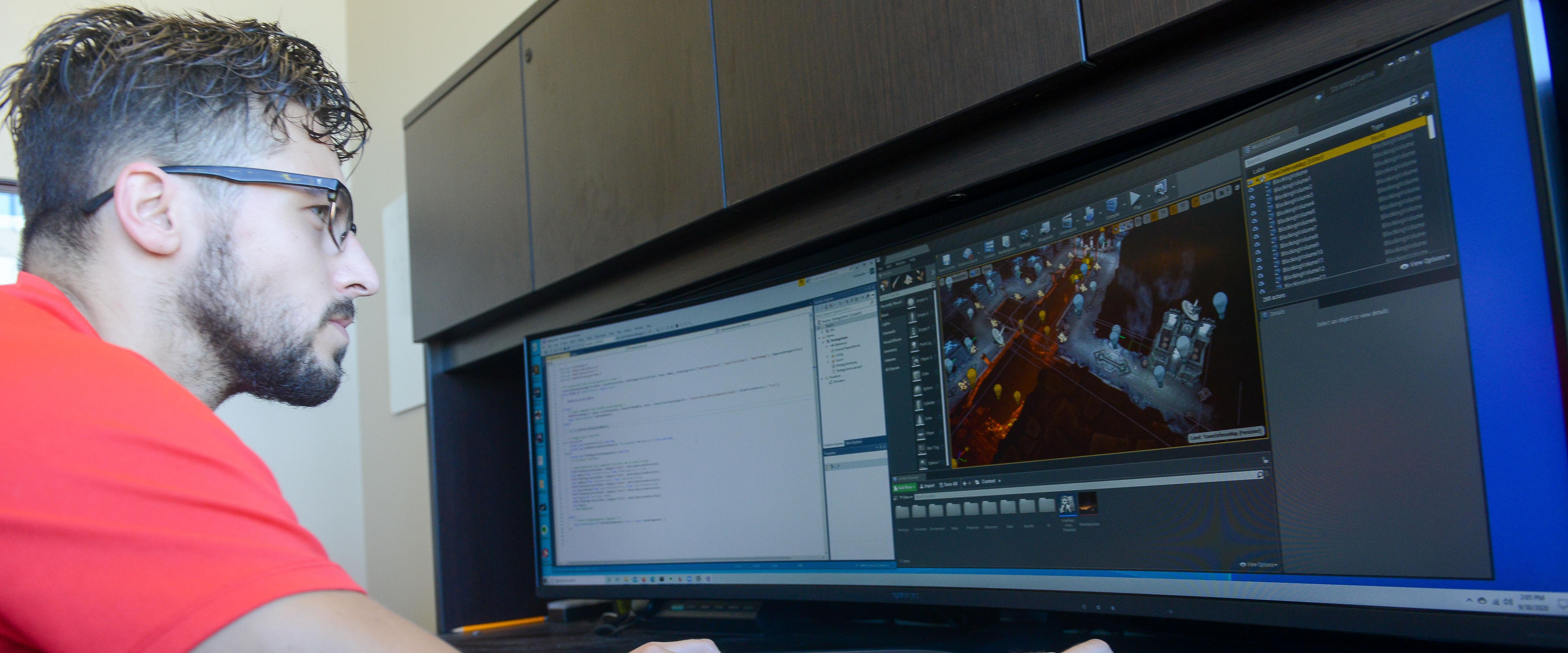 Close up of man sitting at computer working on project