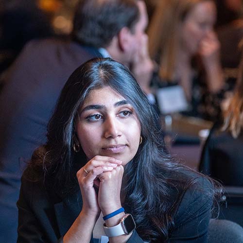 Woman listening to the group discussion while sitting at a table of people during a seminar