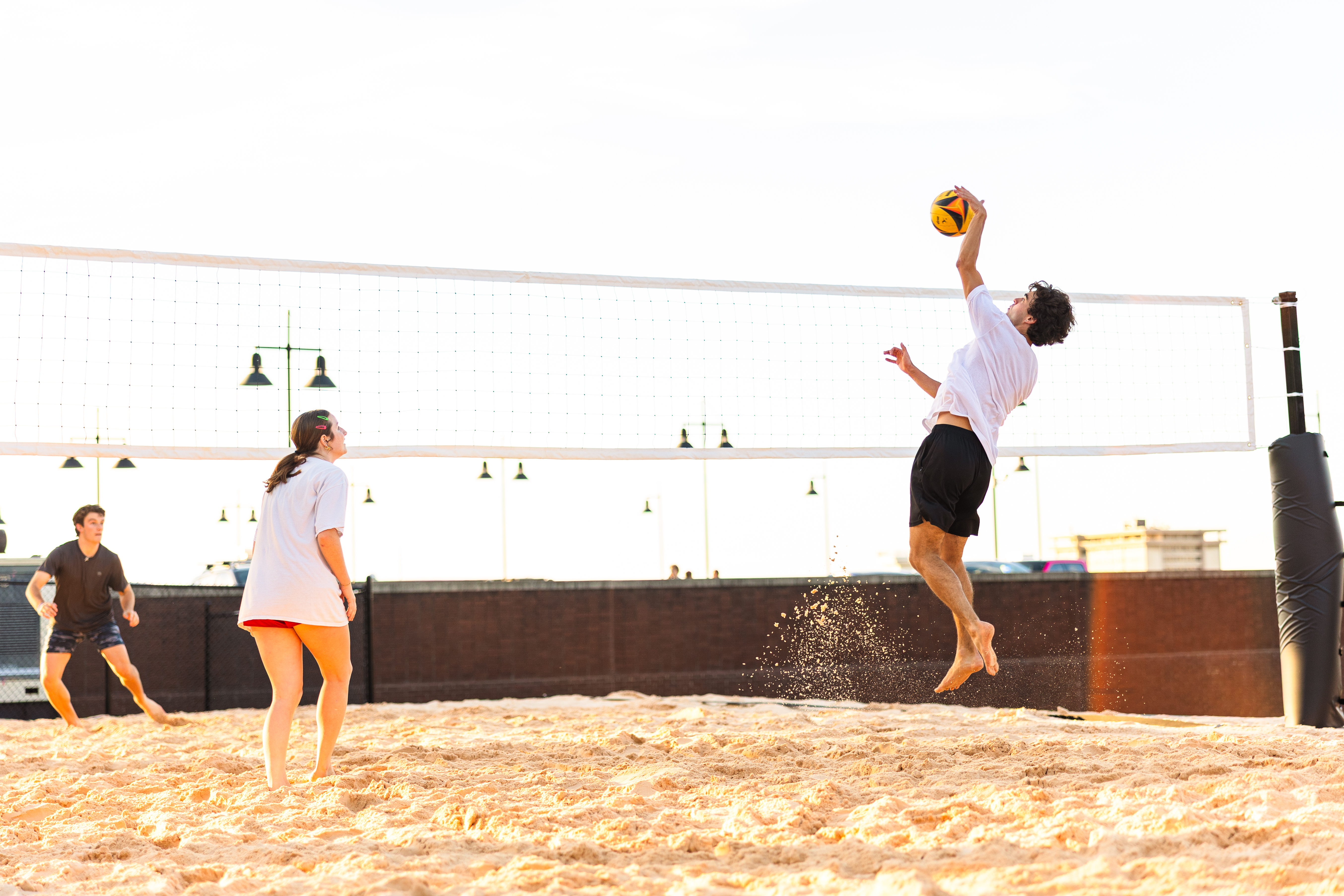 Artistic rendering of outdoor pickleball and beach volleyball courts with students playing and relaxing nearby.