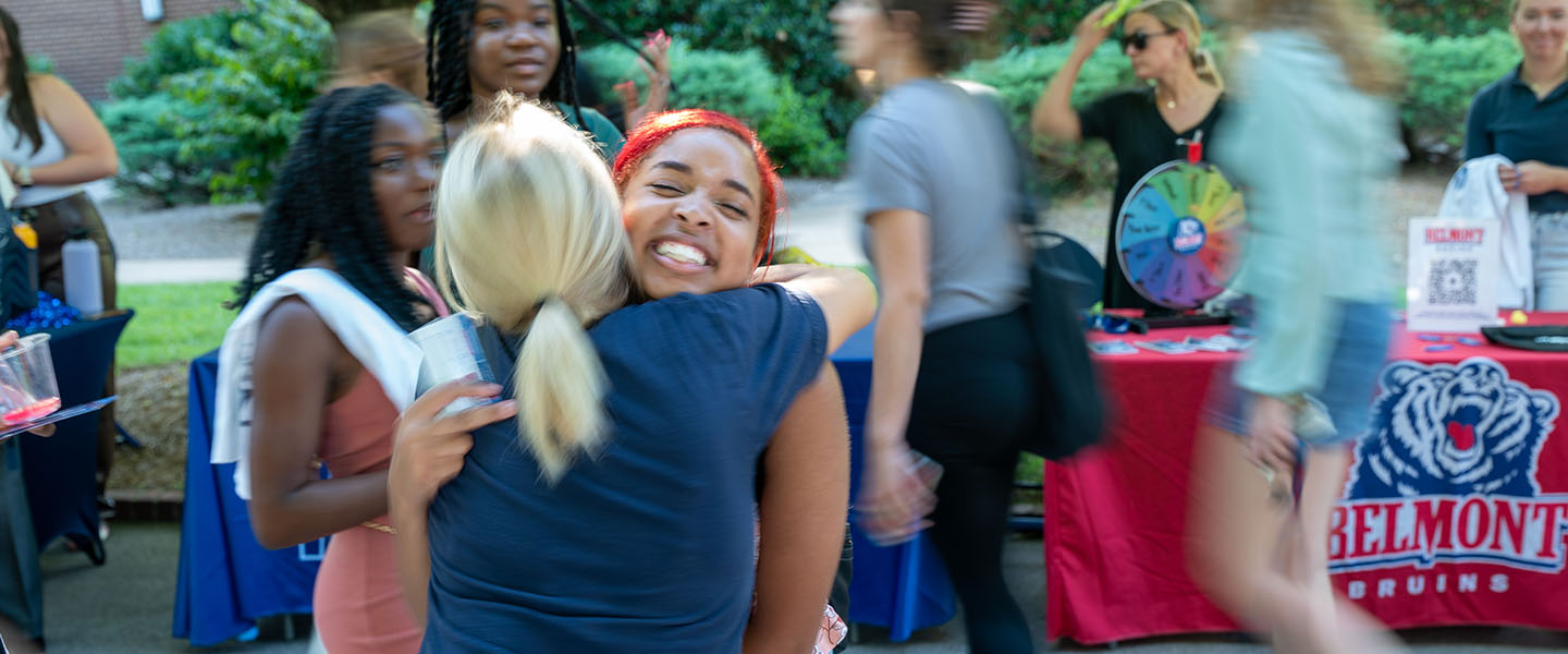 A student hugging another at BruinLink Fair