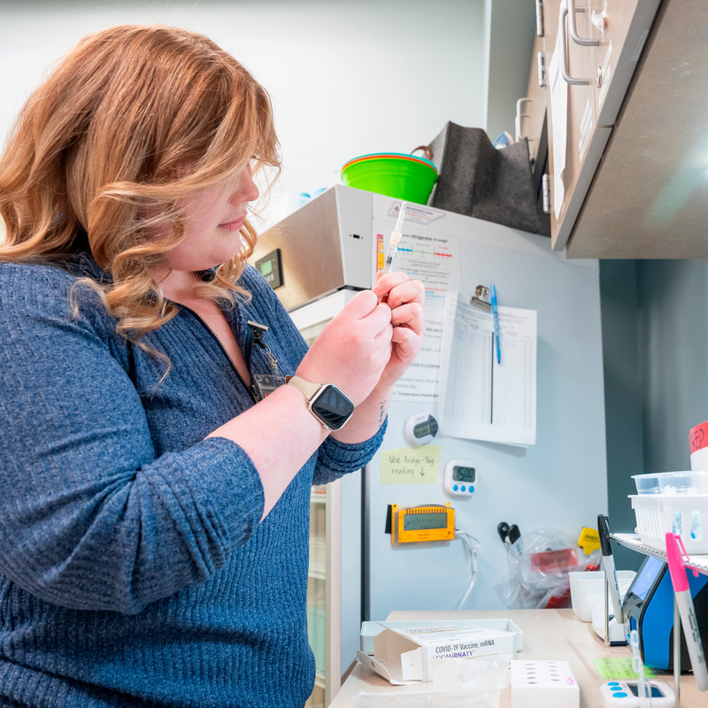 Nurse drawing up a dose from vial