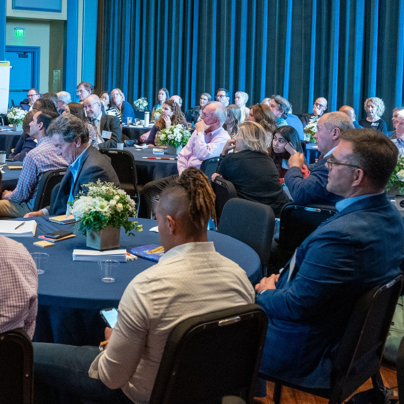 People sitting at tables listening to a speaker at Hope Summit