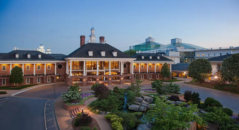 Elegant exterior of Gaylord Opryland Resort at dusk, featuring landscaped gardens, fountains, and the hotel’s brick façade.