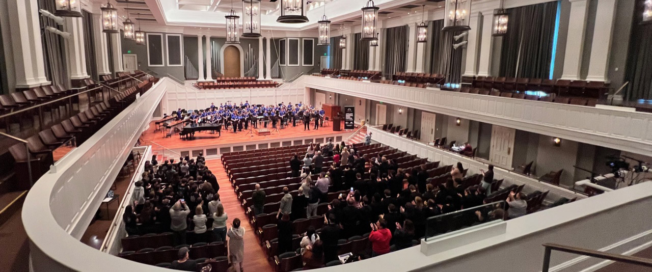 The interior of Belmont's McAfee Concert Hall with the stage lit and filled seats with a small band on stage