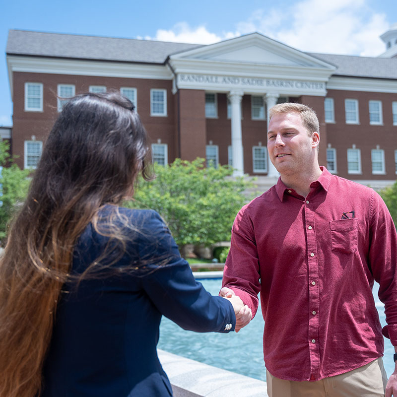 A prospective student meeting a staff member outside the Baskin Center