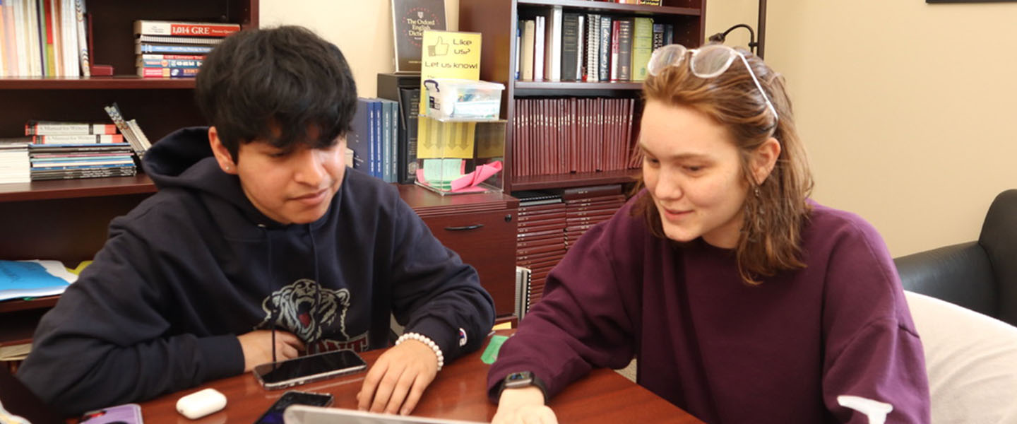 A tutor studying with a student in the Writing Center