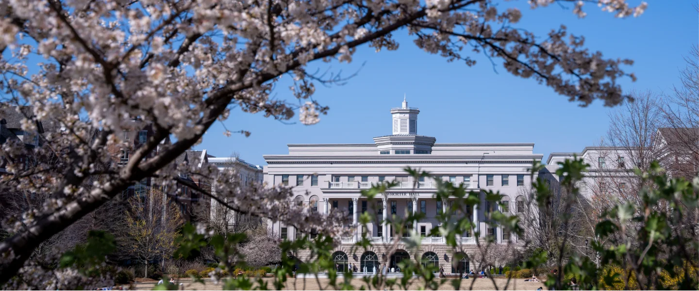 Springtime view of McWhorter Hall, framed by beautiful cherry blossoms and blue sky.
