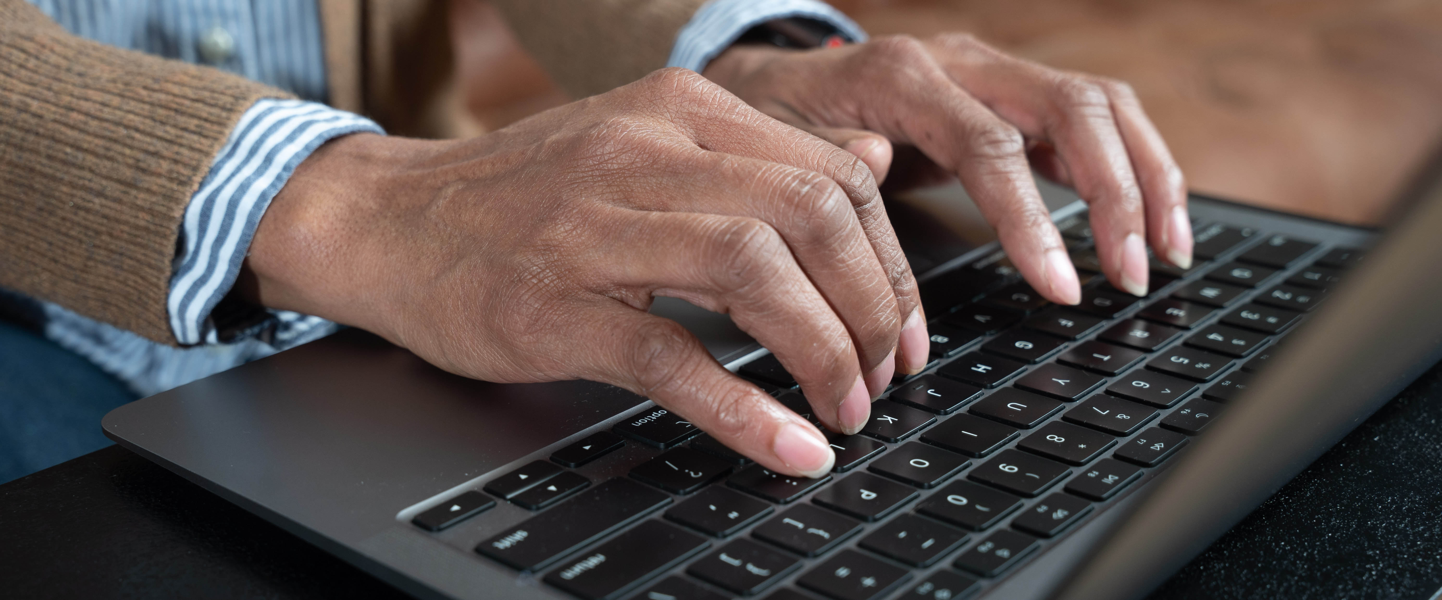 Close up of hands typing on a laptop