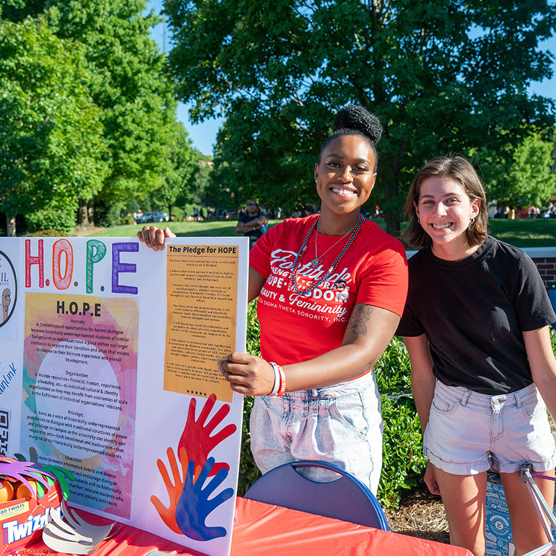 Two students at a table during the Bruin Link Fair 