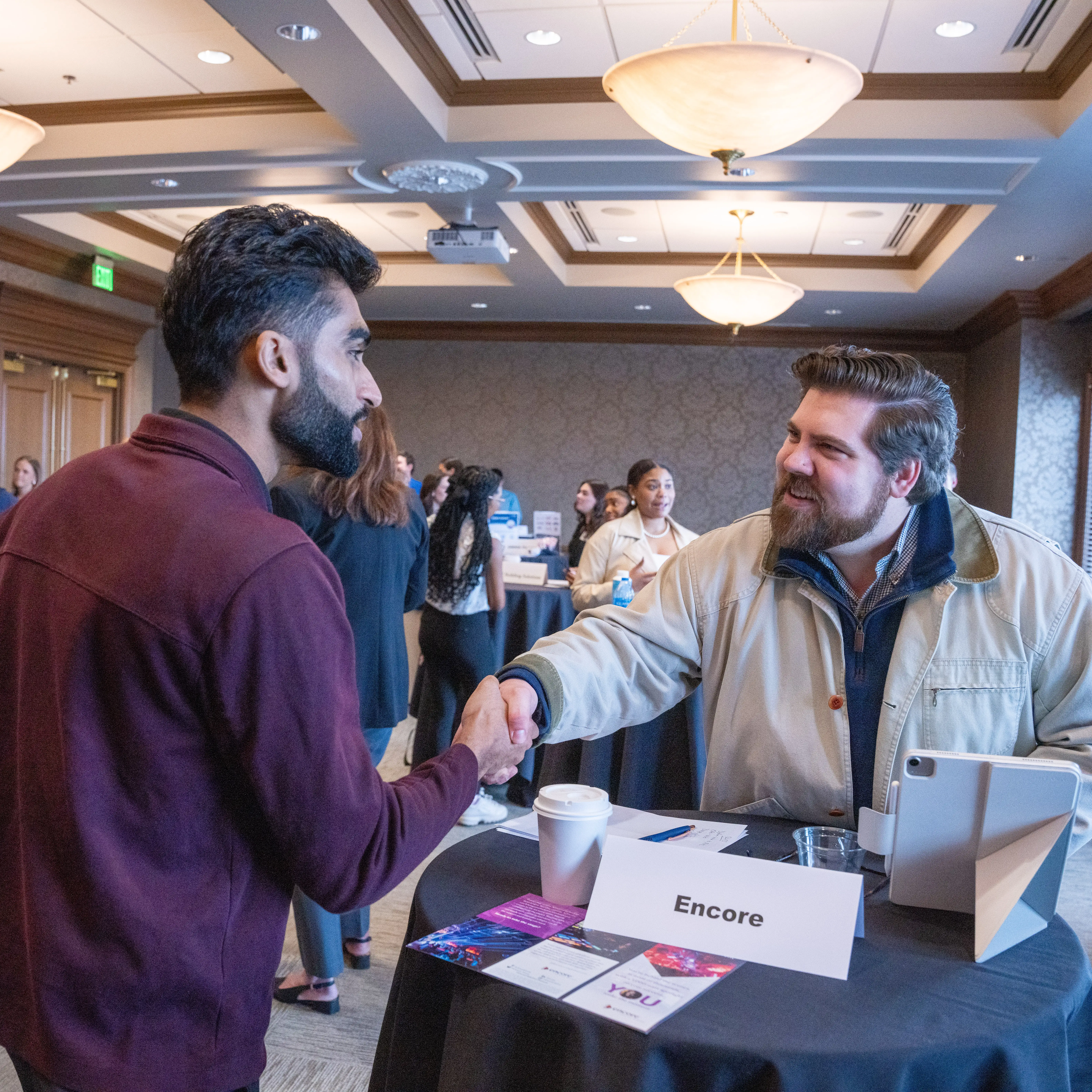 Student holding event materials and smiling during a professional development networking event.