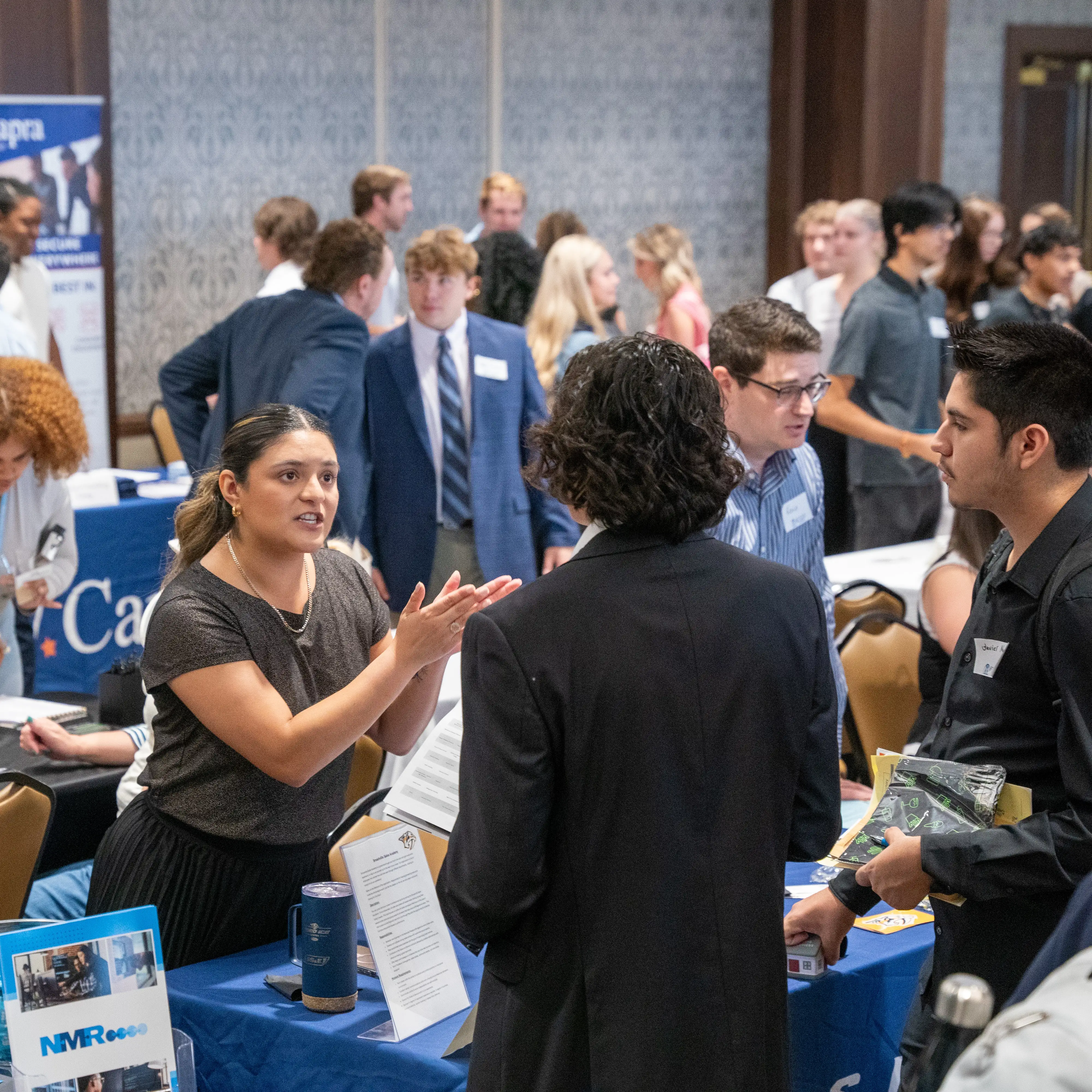 Students networking and speaking with employers during a campus career fair event.