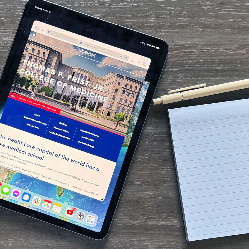 An iPad, notepad and a pen on a desk